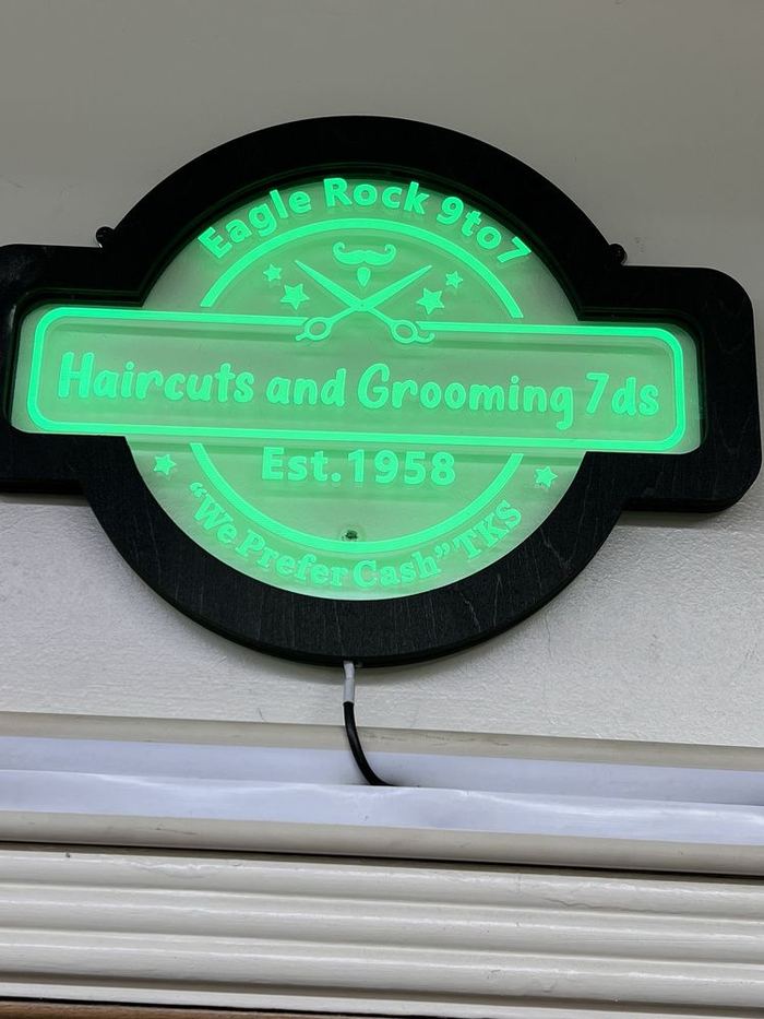 Our green neon sign: Eagle Rock 9 to 7, haircuts and grooming 7 days, Est. 1958